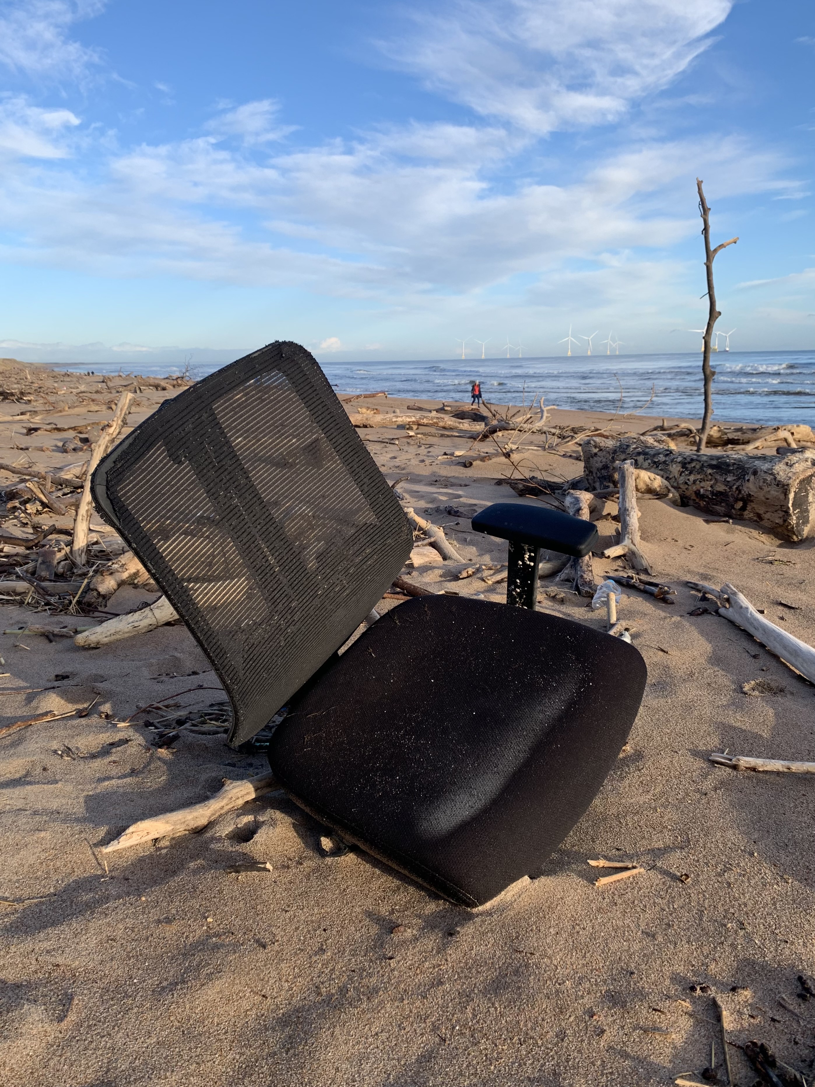 Photo of a discarded office chair on a beach 